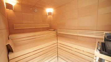 A sauna with wooden benches and a control panel.