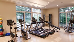 A gym with treadmills, elliptical machines, and weightlifting equipment. - Gasthof Maxlhaid (Wels)