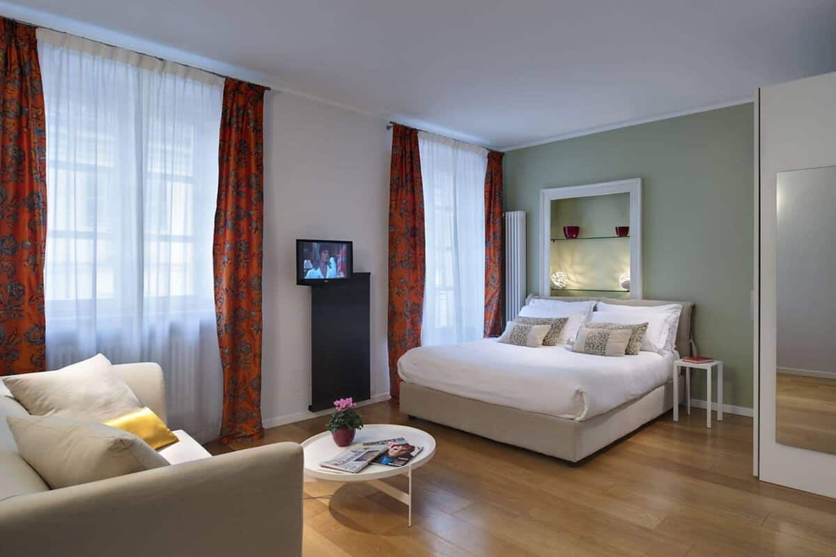 Une chambre d’hôtel moderne équipée d’un lit, d’un canapé, d’une table basse et d’un téléviseur.