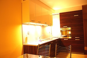 Una cocina moderna con una isla central, horno empotrado y armarios de madera.