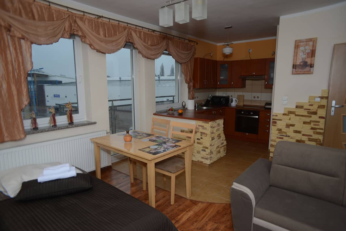 A compact living space with a dining area, kitchenette, and a view of the outside.