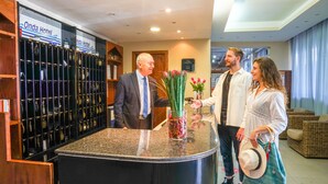 A reception area with a counter displaying a vase of flowers and a sign for 'Onda Hotel'. - Onda Hotel (Silvi)