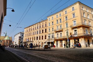 Un bâtiment historique à étages, doté de grandes fenêtres et d’un balcon au rez-de-chaussée.