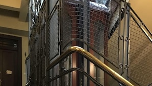 Un escalier orné de rampes en métal ouvragé et doté d’un sol à carreaux.