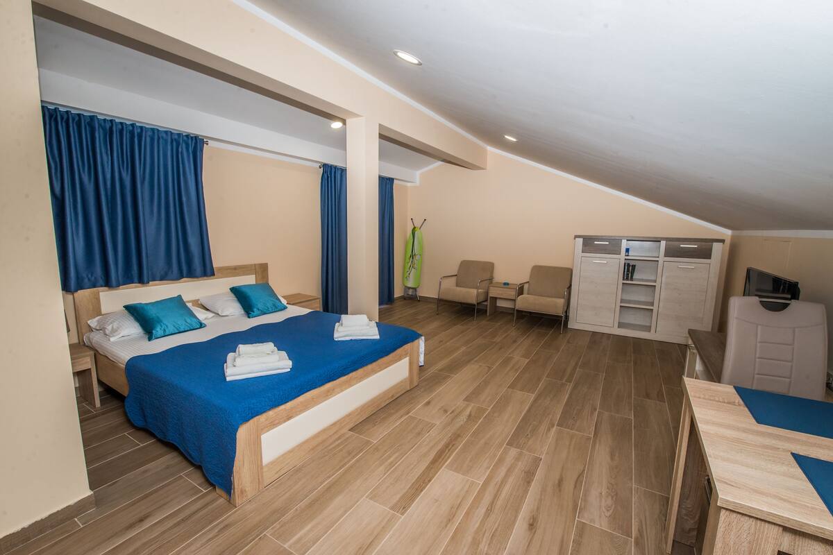 Une chambre à coucher comprenant un lit, un bureau, une chaise et une armoire.