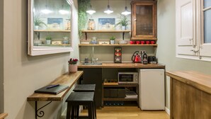 A compact kitchen with a wooden countertop, a small refrigerator, and a window with a view.