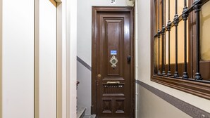 A narrow hallway with a wooden door marked "2a" and a metal railing on the right.