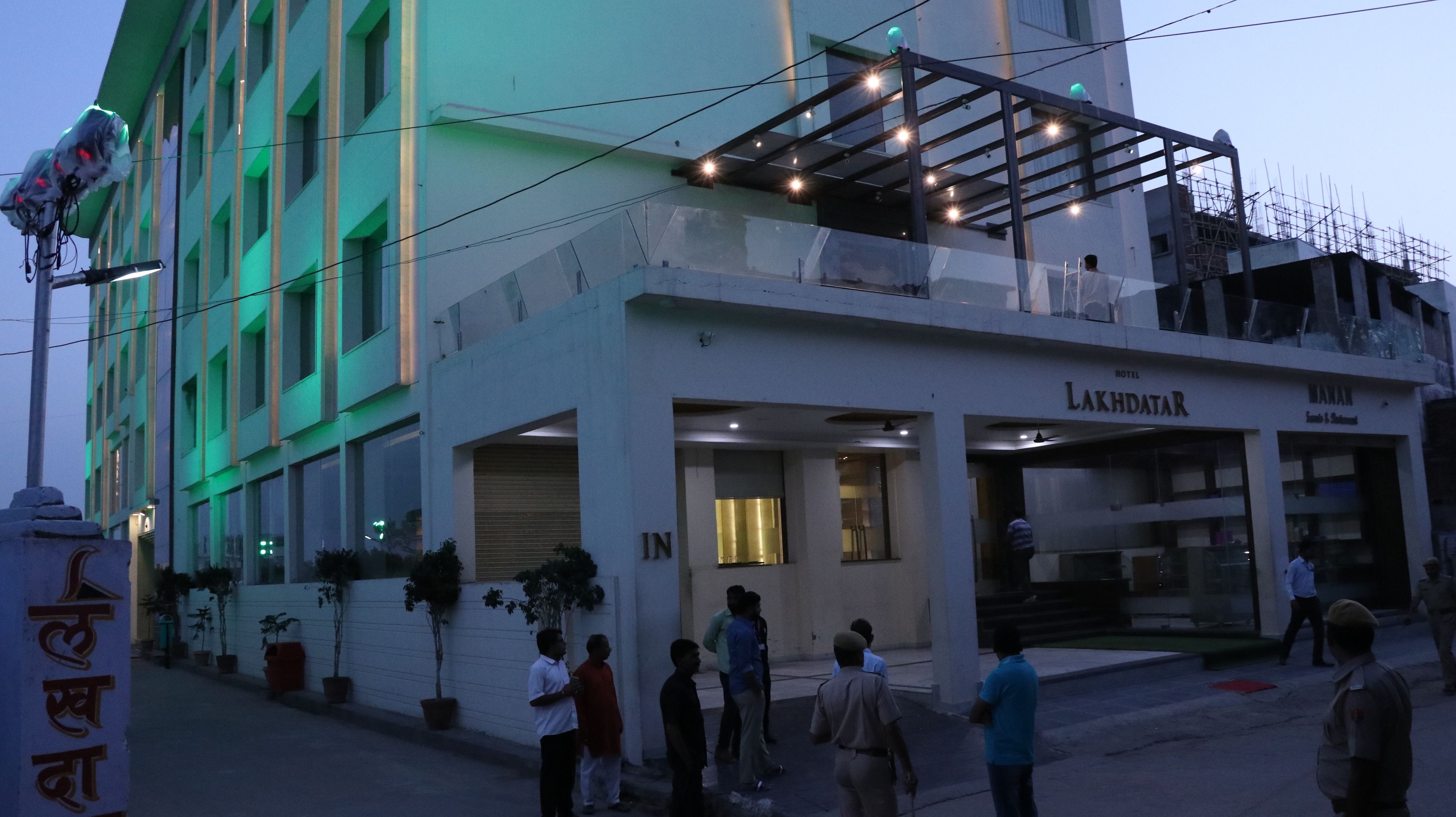 A hotel with a modern facade, a prominent entrance, and a visible restaurant named "Manan".