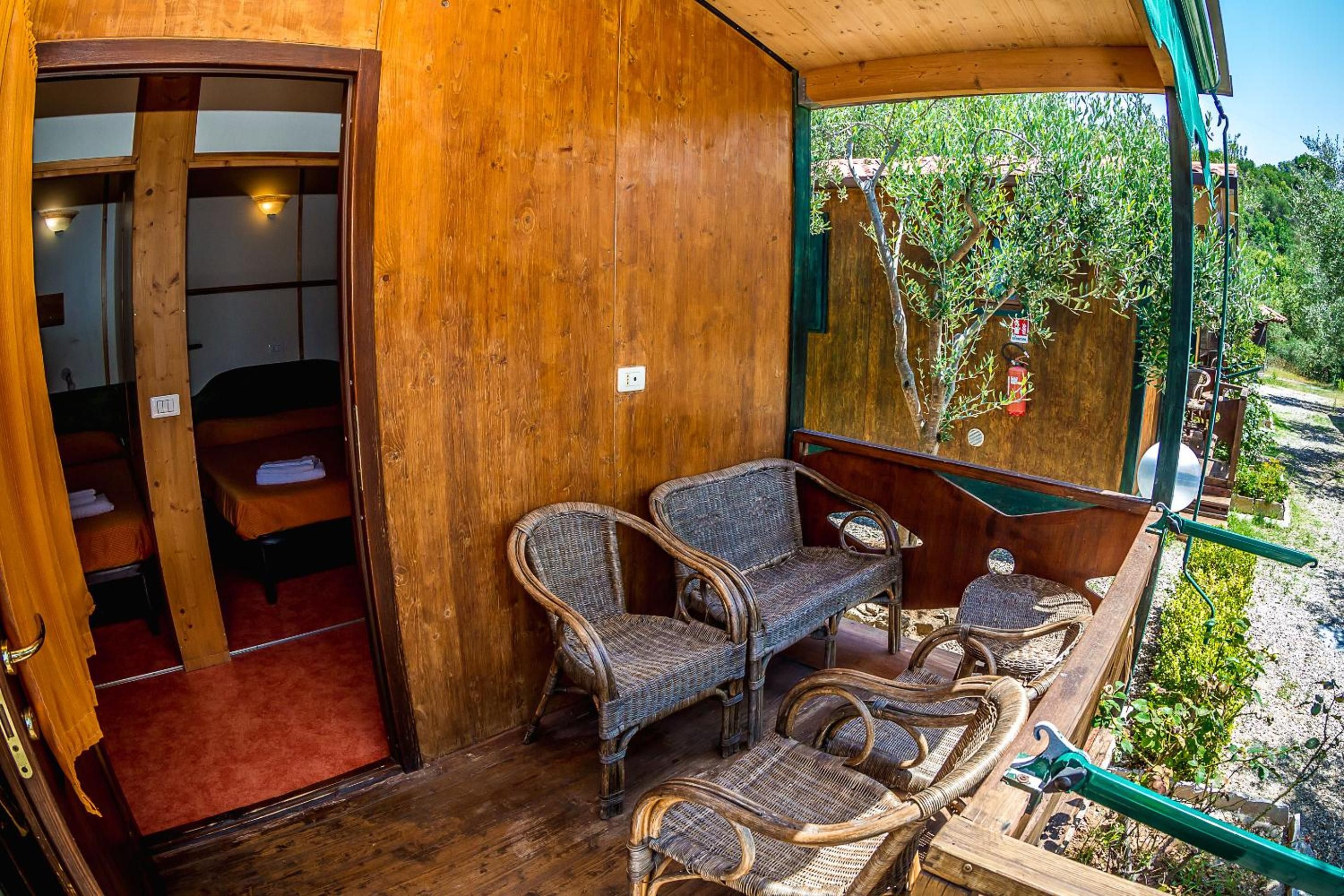 Una habitación de madera con muebles de mimbre y vistas a la vegetación.
