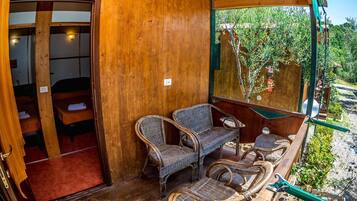 Una habitación de madera con muebles de mimbre y vistas a la vegetación.