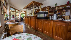 A cozy restaurant with wooden cabinets, a bar area, and a dining area with tables and chairs.