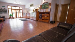 A reception area with a reception desk, seating area, and a large window.