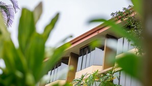 A modern building with large windows and balconies, surrounded by lush greenery. - Hotel Arenal Palace (La Fortuna)