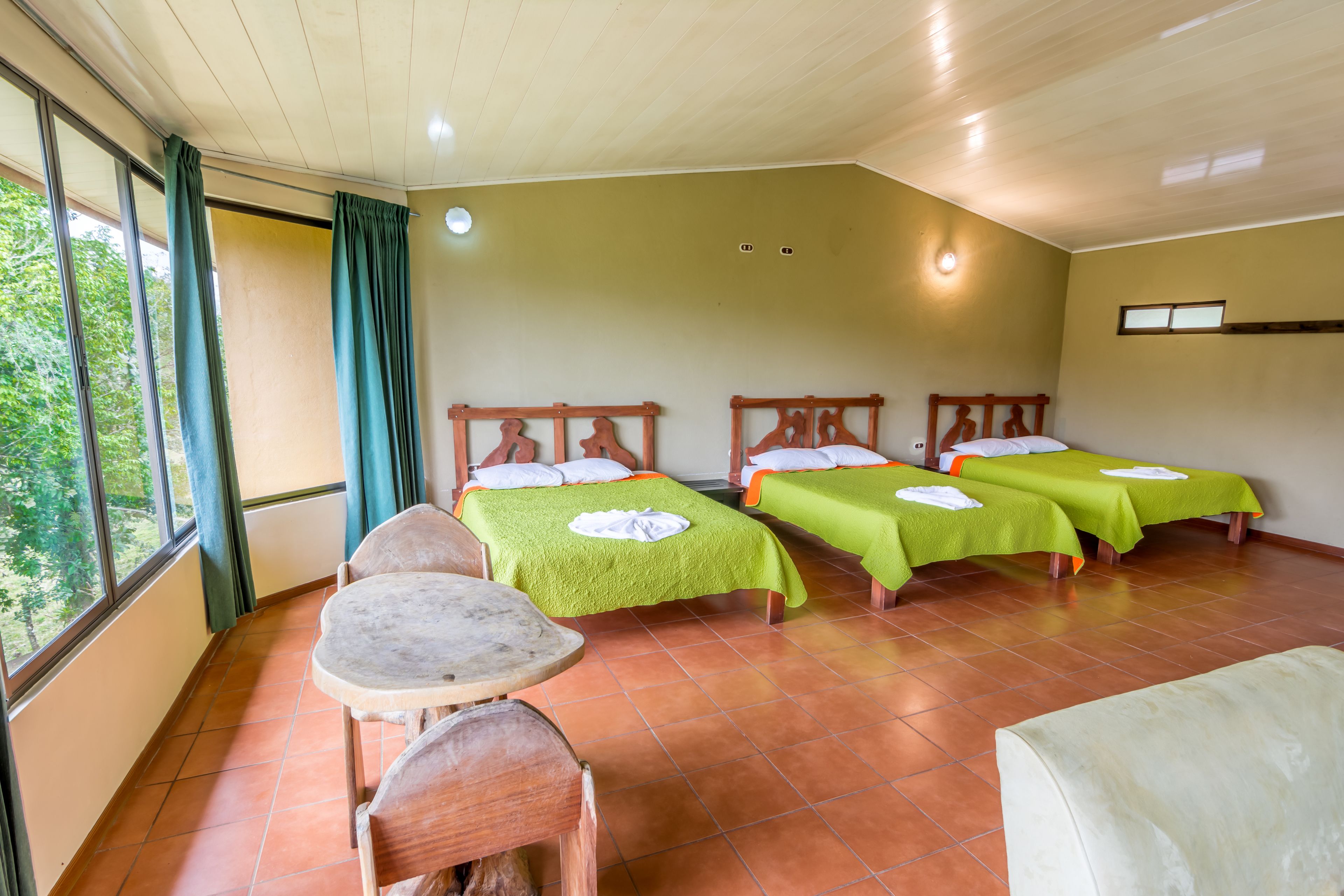 A room with four beds, a small table, and chairs.