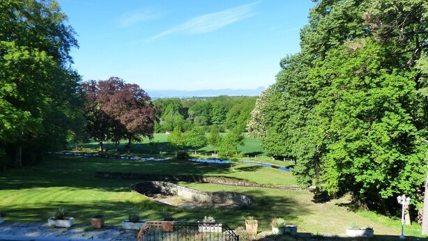 A scenic view of a golf course with lush greenery and a clear blue sky. - Château de Montsablé (Lezoux)
