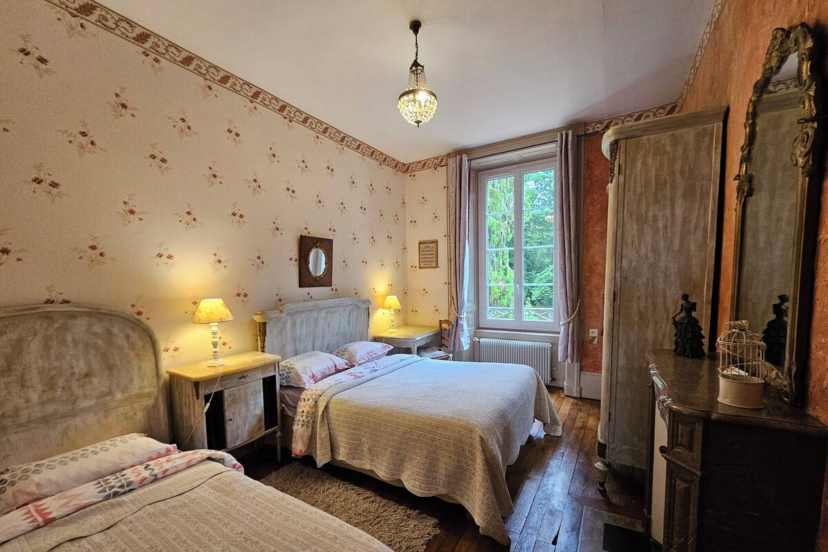 Un dormitorio con dos camas, un aparador, un espejo y una ventana con cortinas.