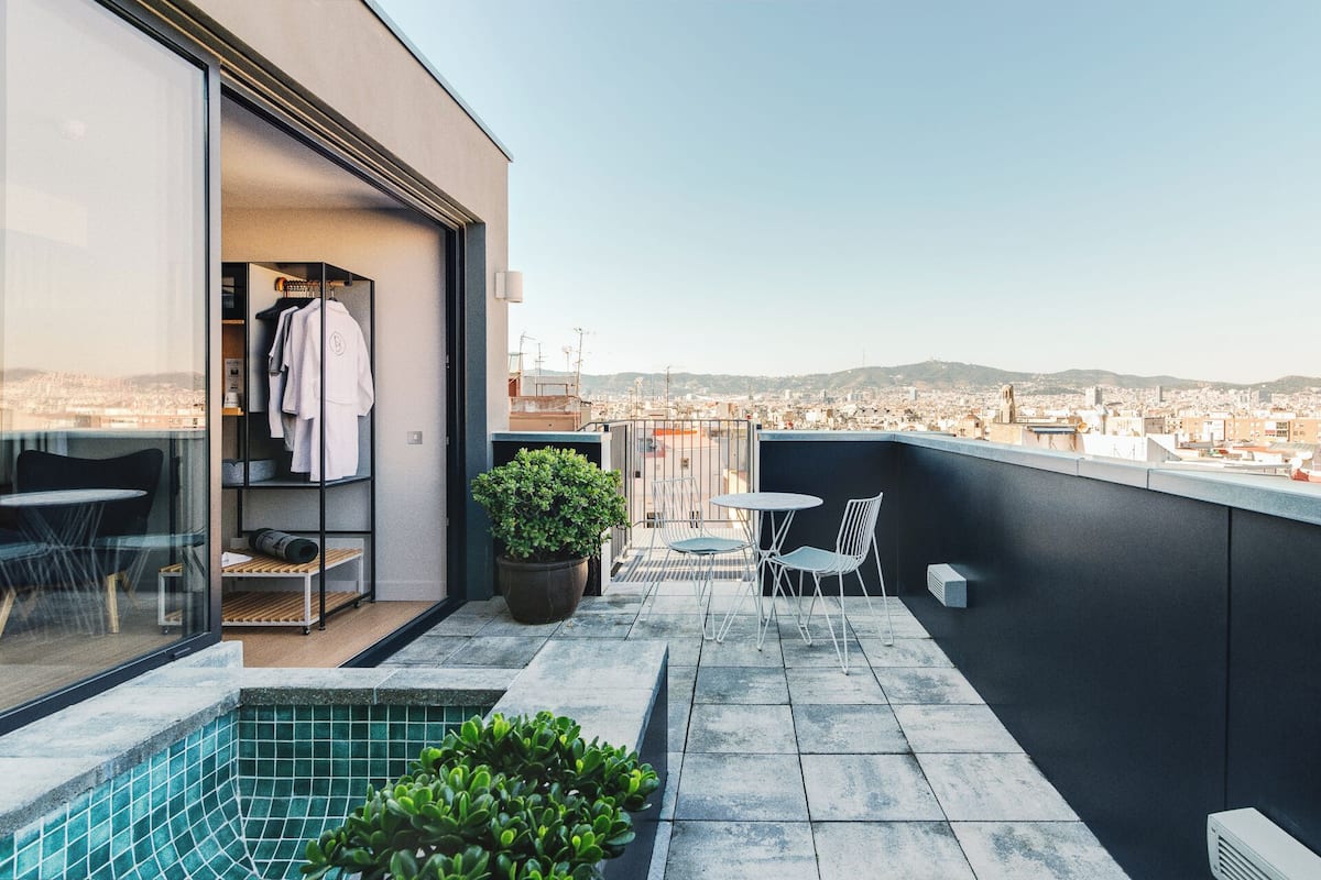 A rooftop terrace with a pool, seating area, and a view of the cityscape.