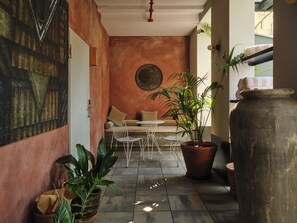 A cozy indoor seating area with a sofa and chairs, surrounded by potted plants and a large vase. - Hotel Brummell (Barcelona)