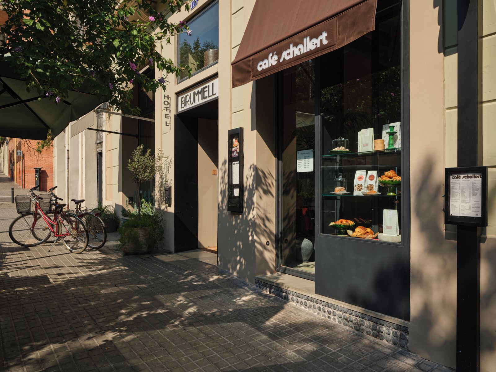 Una cafetería con toldo marrón y una pizarra con la carta.