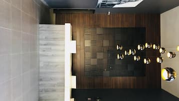 A modern reception area with a wooden panel wall, a reception desk, and a series of wall-mounted lights.