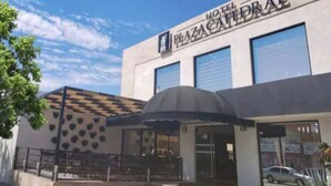 Un hotel con fachada moderna, un acceso cubierto y un cartel que dice "Hotel Plaza Catedral".