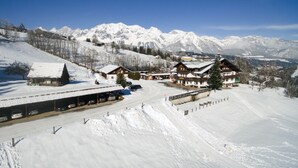 A snow-covered mountain village with a ski resort, including a hotel and a parking area. - Seiterhof (Schladming)