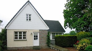 A small, single-story house with a gabled roof and a front door. - Westacre Lodge Self Catering Chalet (Crieff)