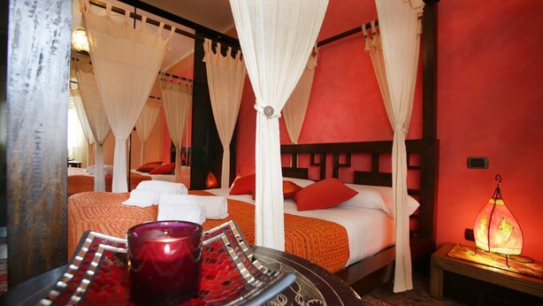 A room with a bed, a table with a candle, and a hanging lamp. - Easy Dream Rooms (Verona)