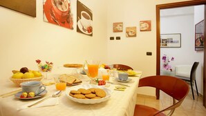 A breakfast table set with various food items, a coffee cup, and a juice pitcher. - Easy Dream Rooms (Verona)