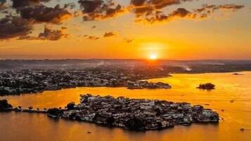 Vista aérea de un pueblo costero con un río y un atardecer.