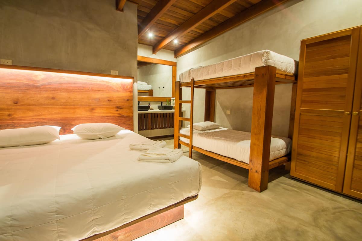 Un dormitorio con una cama litera, un armario de madera y un espejo.