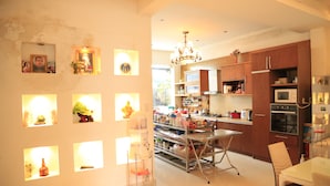 A modern kitchen with stainless steel appliances, a central island, and a chandelier. - Hoai Huong Homestay (Lam Vien - Da Lat)