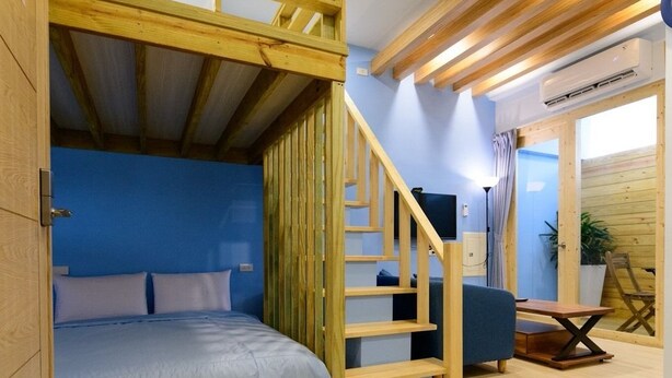 A room with a bunk bed, a wooden staircase, a desk, and a chair. - Summer Sea Hostel (Magong)