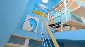A staircase with a blue wall and a dolphin painting. - Summer Sea Hostel (Magong)