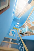 Una escalera con una pared azul y una pintura de delfín.