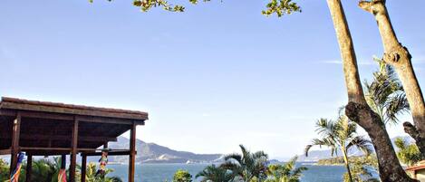 Un restaurante frente al mar con terraza, con vistas al océano y a las montañas.