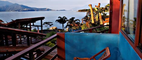 Um deck de madeira com vista para um corpo de água e montanhas.