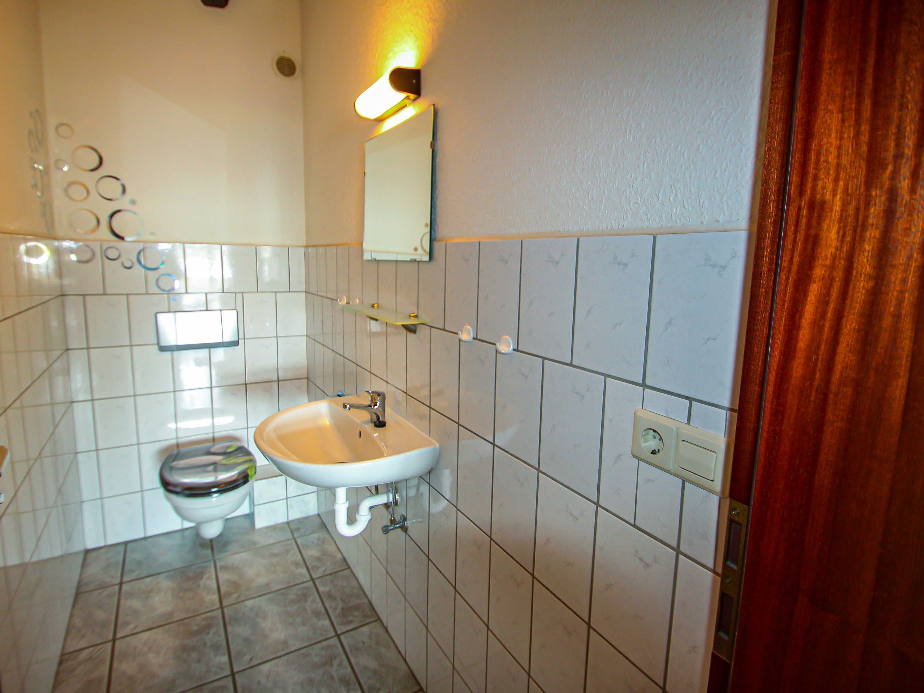 Une salle de bain avec des toilettes, un lavabo et un miroir.