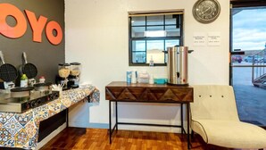 Una kitchenette con máquinas para hacer gofres, cafeteras y un reloj en la pared.