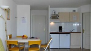 A compact living space with a dining area, kitchenette, and a small seating area. - Les Parasols d'Argens (Roquebrune-sur-Argens)