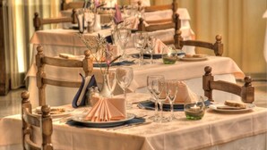 A formal dining table set with chairs, glassware, and a centerpiece. - Hotel Hamilton (Misano Adriatico)