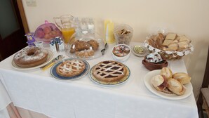 Un buffet de petit-déjeuner proposant un assortiment de viennoiseries, de pains et de boissons.