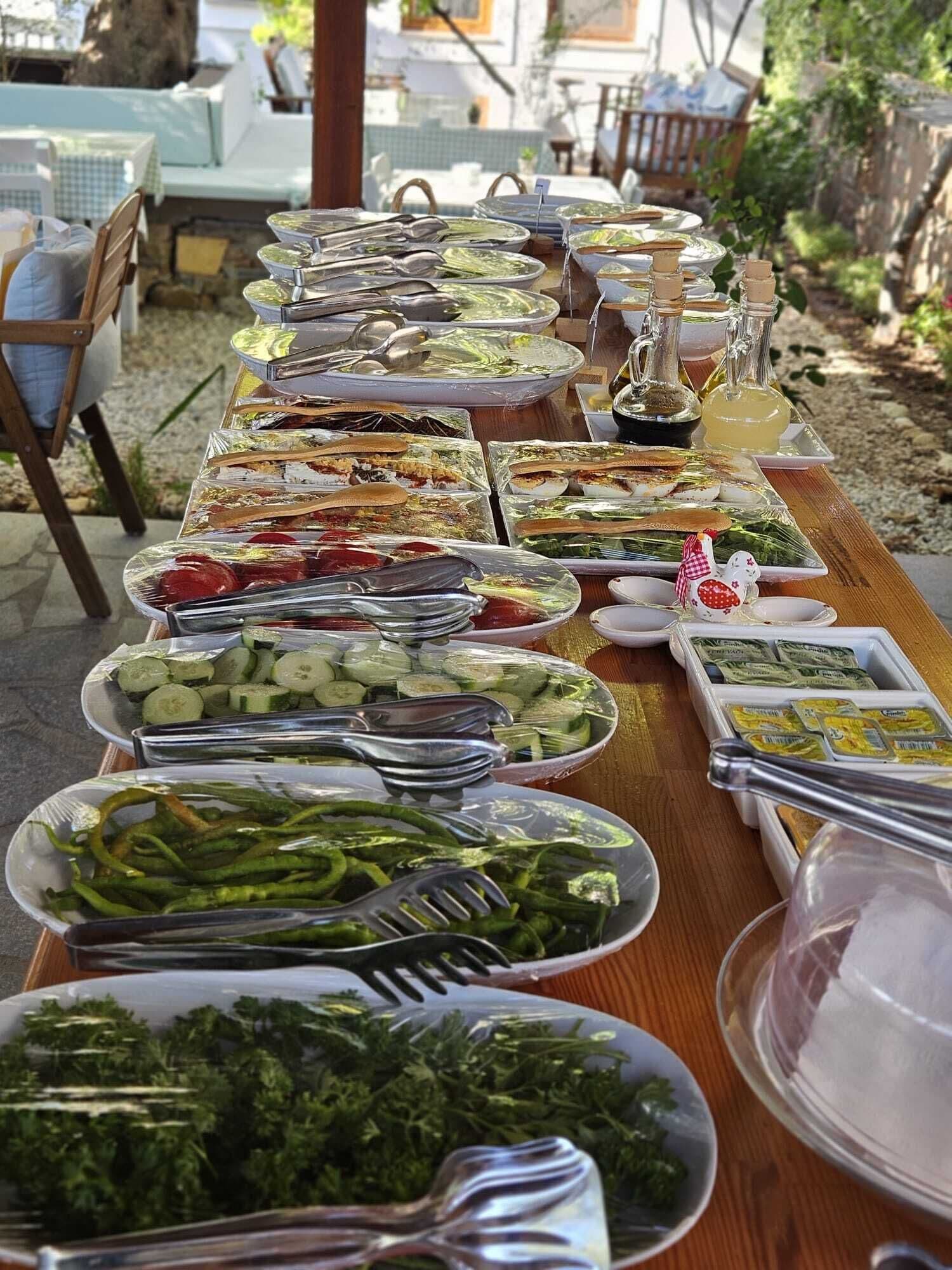 A buffet table with various food items and utensils.