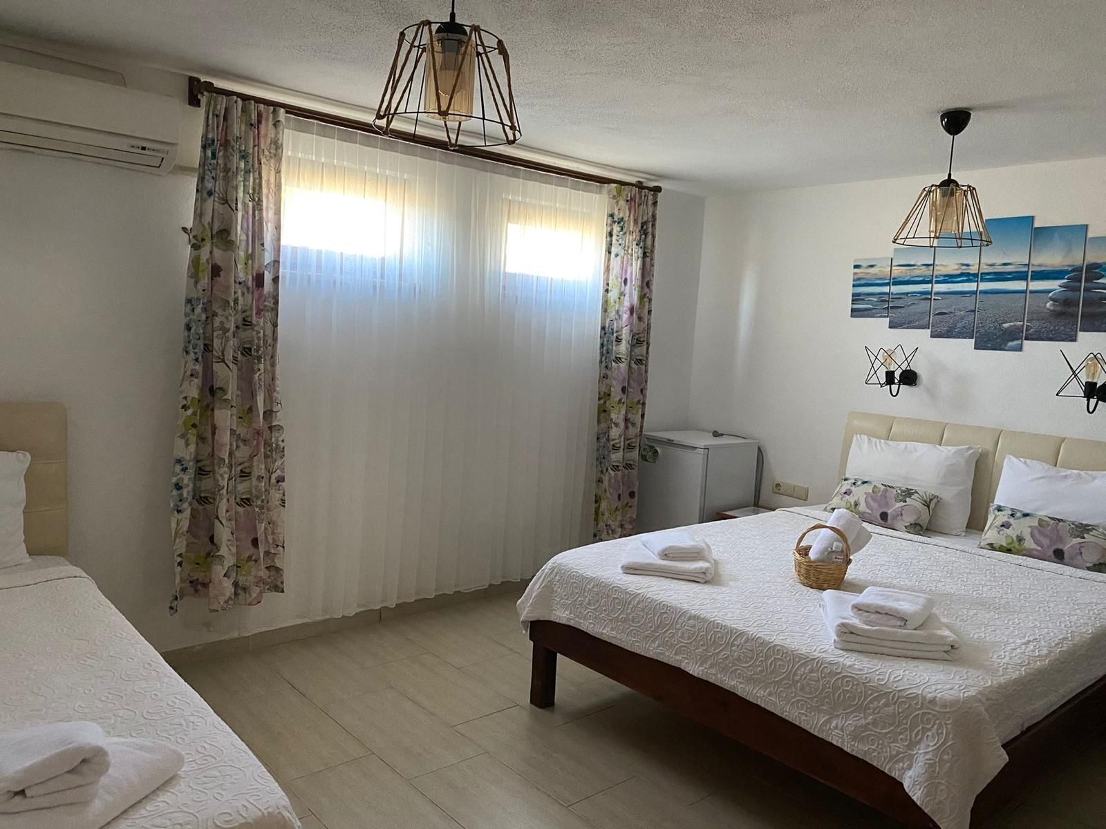 A hotel room with a bed, a bedside table, a lamp, and a wall-mounted TV.