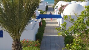 Un sendero que conduce a una playa con edificios blancos y palmeras.