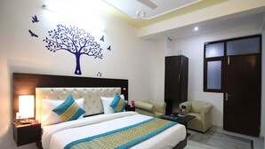 Une chambre d’hôtel avec un grand lit, une table de chevet, un bureau, une armoire et une fresque murale.