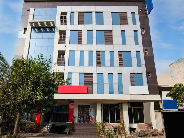 A multi-story hotel with a modern facade, featuring a mix of glass and brickwork.