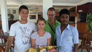 Un grupo de personas en un restaurante con una bandeja grande de frutas y verduras.