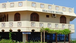 Un hotel con recepción, ventanas arqueadas y vista al mar.