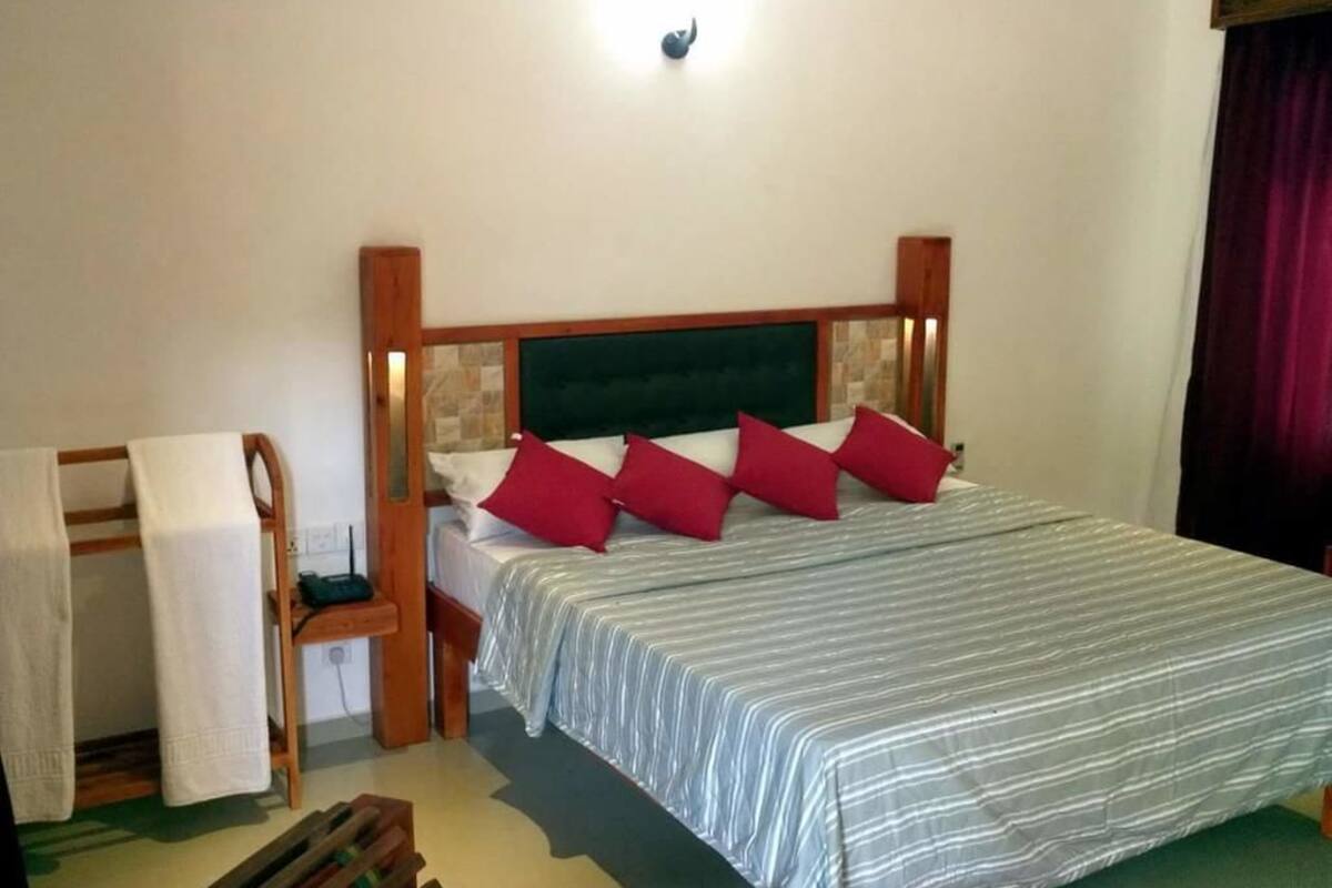 Un dormitorio con una cama, un banco de madera y una pequeña mesa.